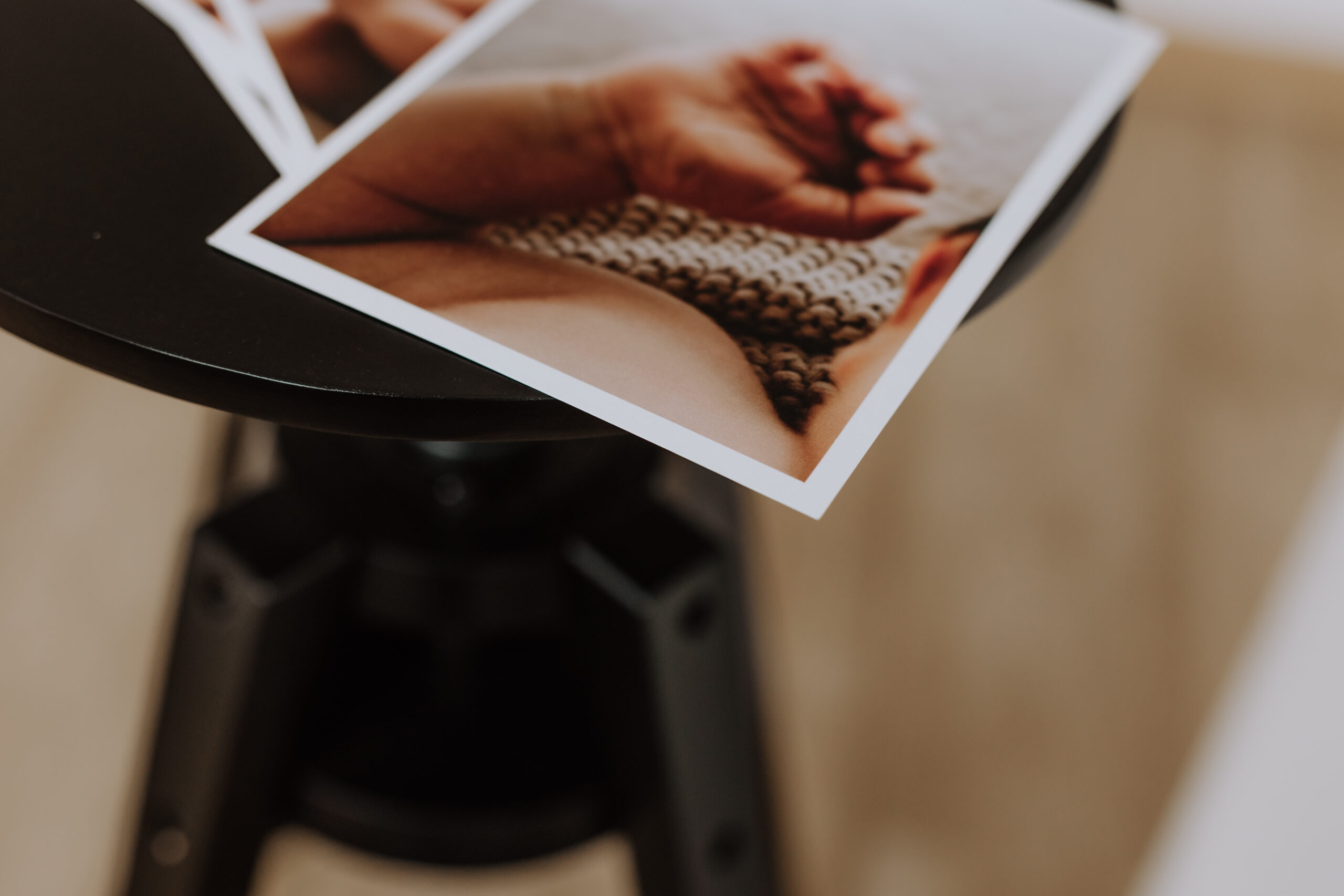 Fotoshooting Preise & Pakete mit Fotoabzug liegt auf schwarzem Hocker.