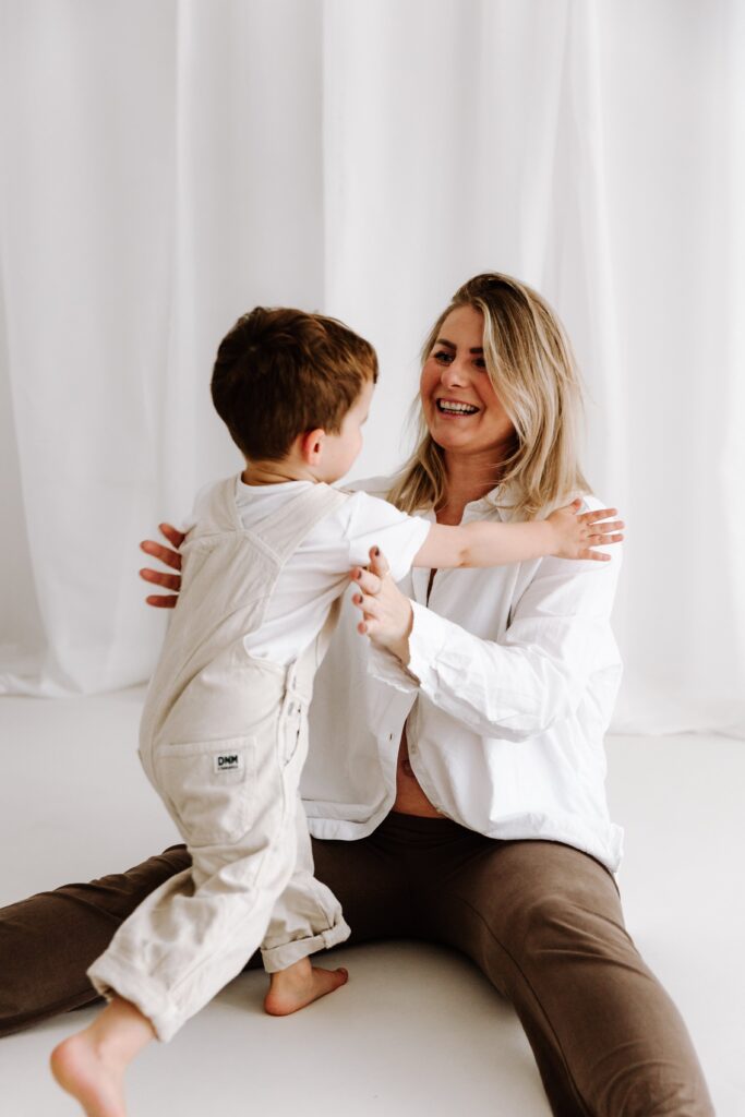 Geschwisterkind beim Babyshooting läuft in Mamas Arme