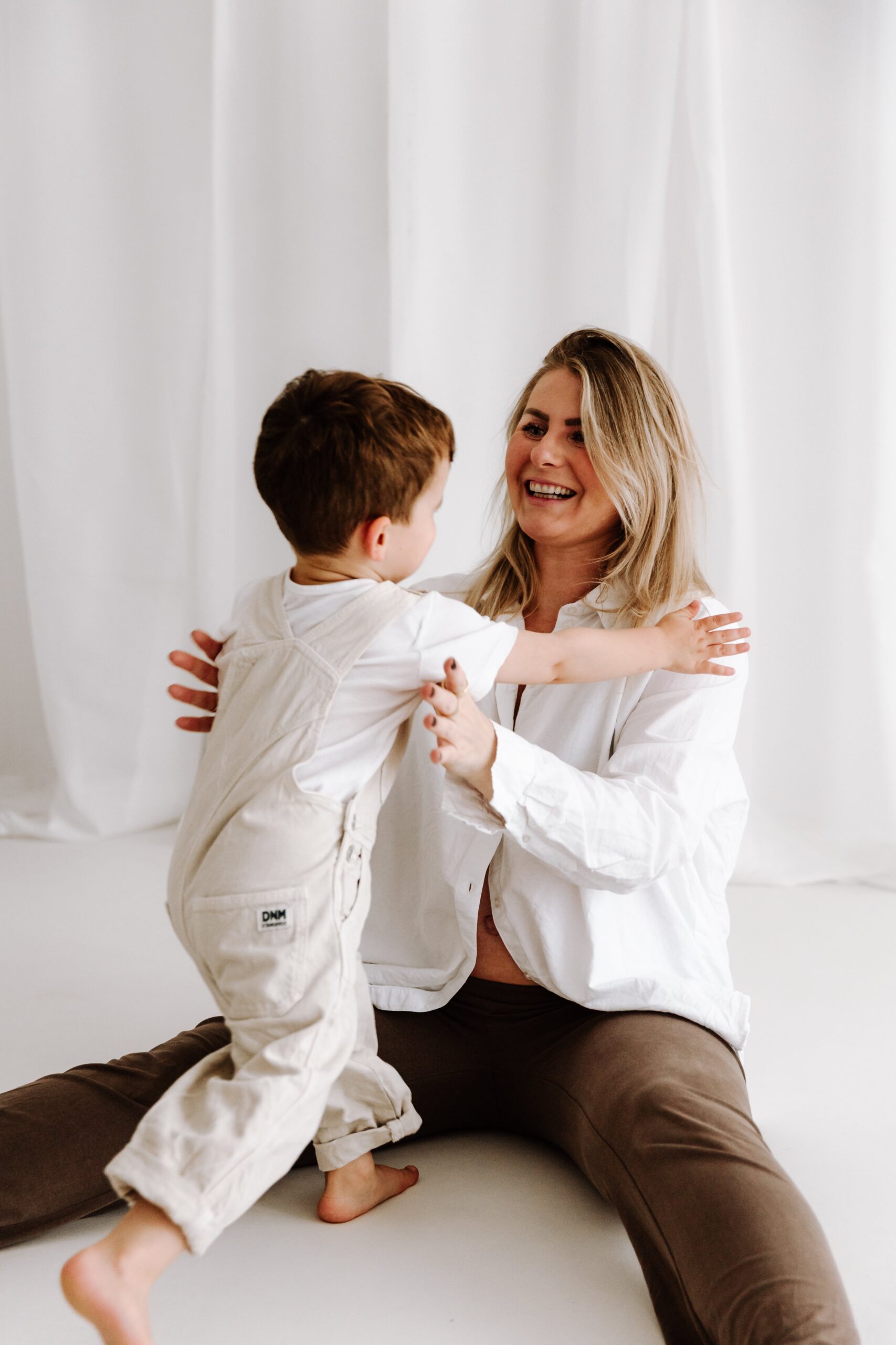 Geschwisterkind beim Babyshooting läuft in Mamas Arme