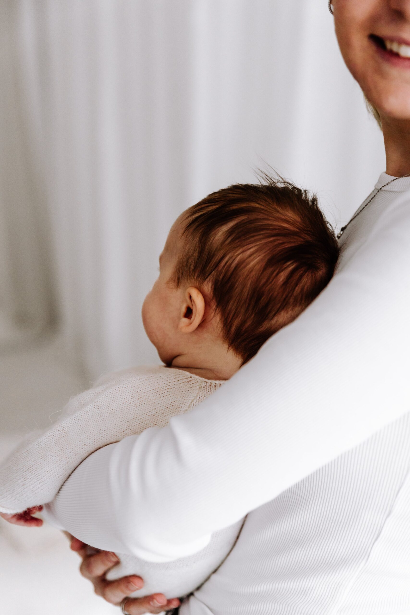 Baby im Arm von Mama im Fotostudio.