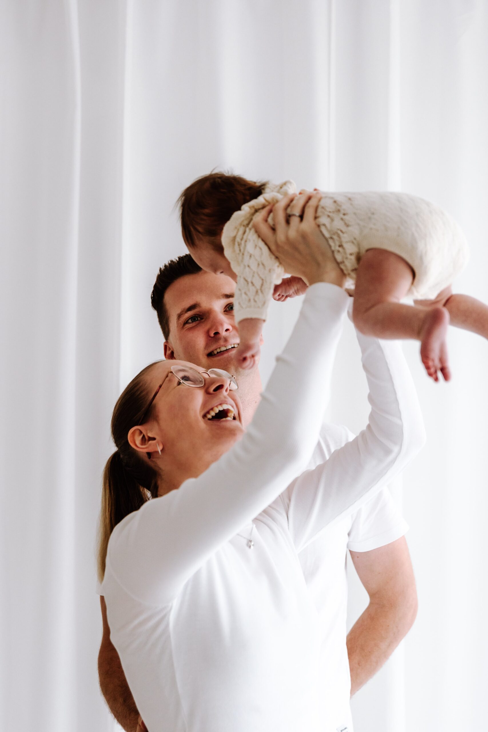 Baby in Mamas Armen im Fotostudio